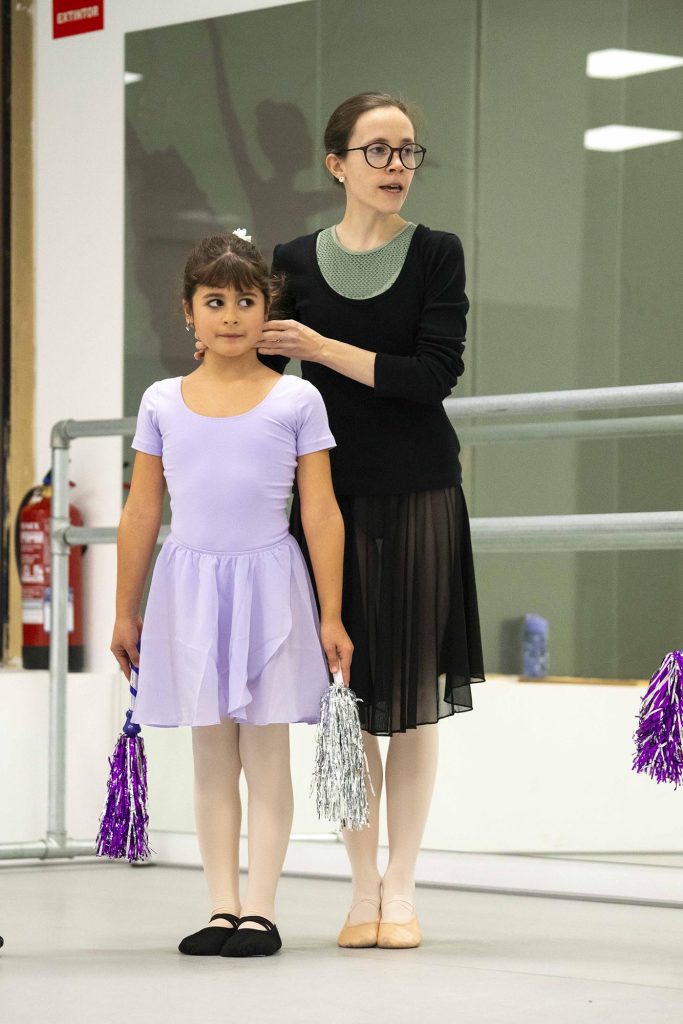 Irene Álvarez corrigiendo la colocación de una alumna durante una clase de ballet elemental infantil