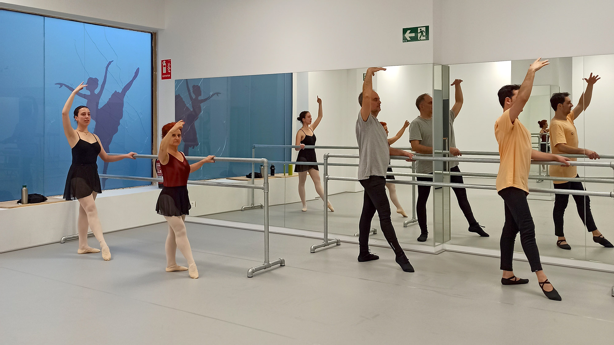 Grupo de iniciación de adultos realizando ejercicio de barra en Madrid Río Escuela de Danza