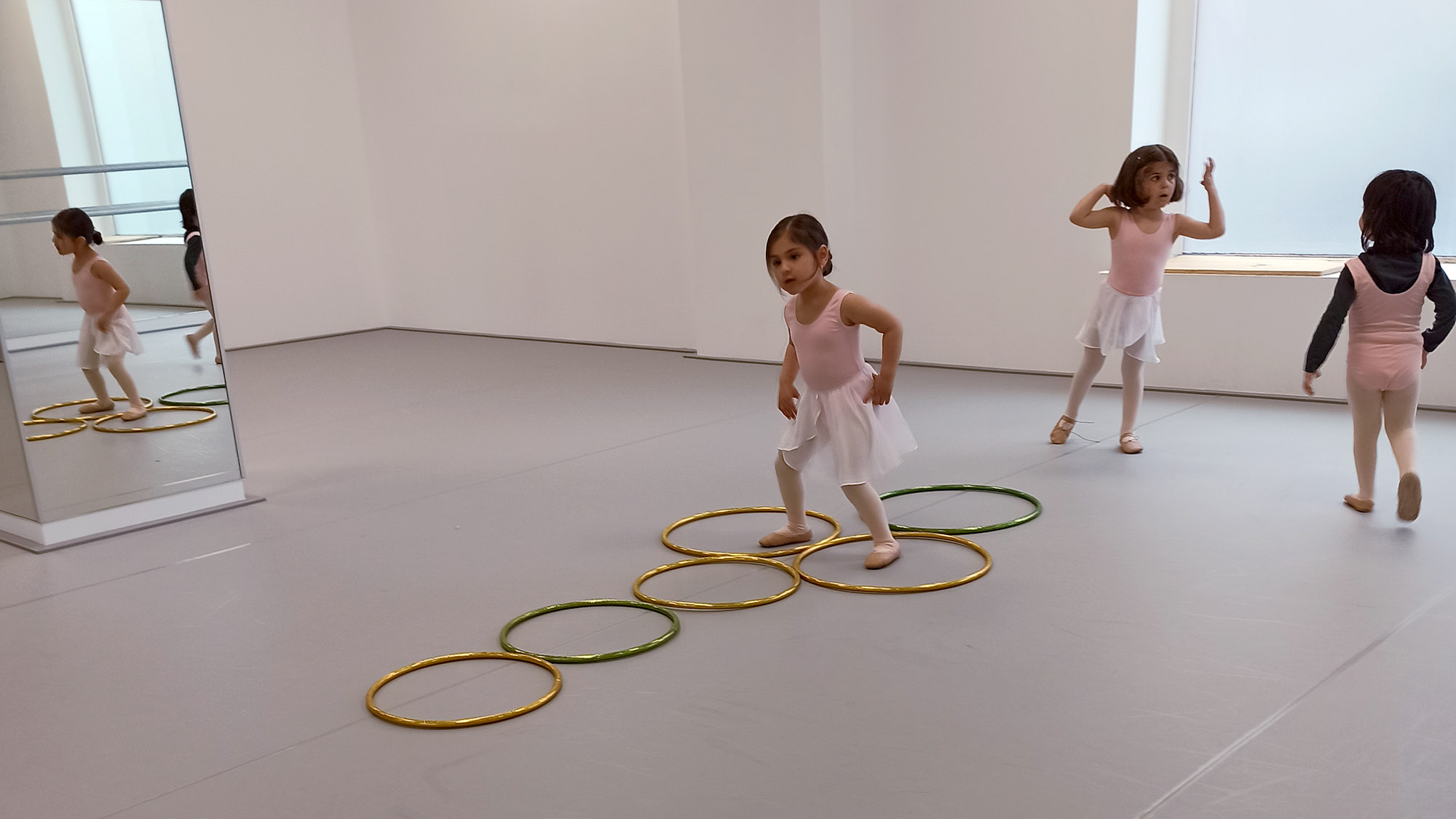 Tres alumnas de predanza (+3 años) realizando un ejercicio con aros en Madrid Río Escuela de Danza